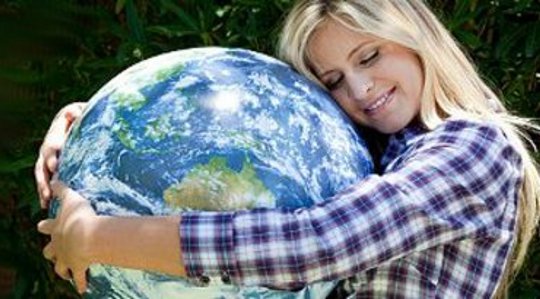 young woman hugging a globe of Planet Earth