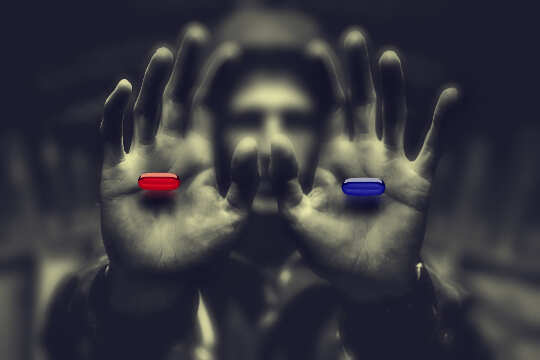 Know Thy Enemy: Evolving Beyond the Status Quo man in shadows holding out a red pill in one hand and a blue pill in the other