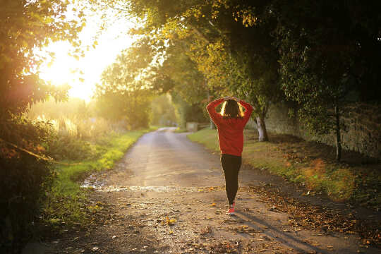 Using Our Intuitive Gifts in The Age of Aquarius girl walking on a country road toward a bright light in the distance