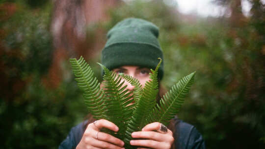 Overcoming Fear in Communication: The Price of Positive Change a young man holding some ferns and using them to hide behind