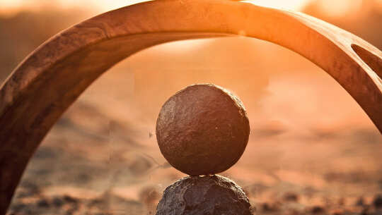 Attaining Balance Between Left and Right-Brain by Nourishing the Solar Plexus Chakra two balls balanced on top of each other under an arch