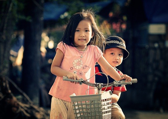 Understanding the Challenges of Our Life’s Journey young girl on a bicycle with her brother sitting behind her