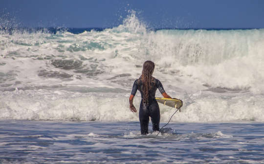 The Overload Syndrome: How To Deal with It and Learn to Say "No" surfer with tiny surfboard facing huge waves