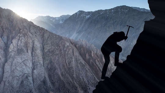 Allow The Fear, Transform It, Move Through It, and Understand It photo silhouette of mountain climber using a pick to secure himself