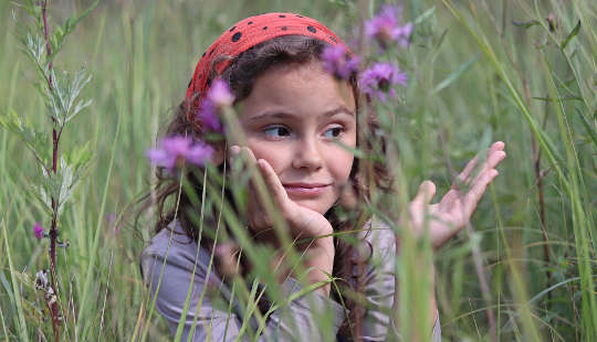 How To Live Beyond Worry and Fear young girl in a field of tall grasses and wildflowers