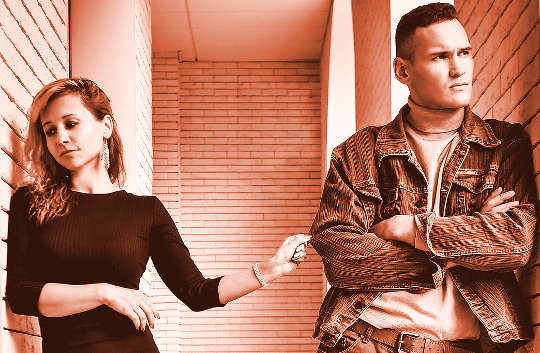 Regrets: Why and How to Make an Apology a couple standing on opposite sides of a hallway not looking at each other