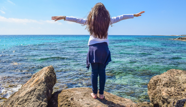 How to Connect with God -- Even If You’re an Atheist young girl with arms wide open in front of the ocean