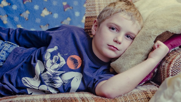 Surviving the Holidays and the Myth of Happily-Ever-After Families cranky-looking young boy laying on the couch