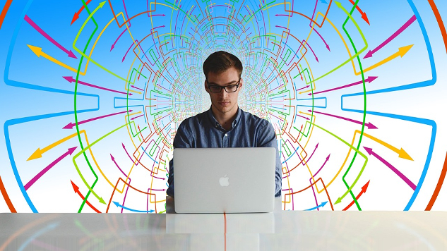 How to Rise Above the Confusion man sitting at a computer with a complicated drawing of charts and graphs behind him