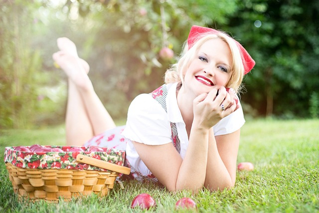 Are Attractive People Really More Trustworthy? pretty woman outside laying on the grass smiling