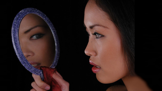 We Teach Best What We Need to Learn a woman looking at herself in a hand-held mirror