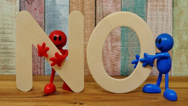 two figures, one red one blue holding up the letters NO. Image by Alexa from Pixabay.&nbsp;
