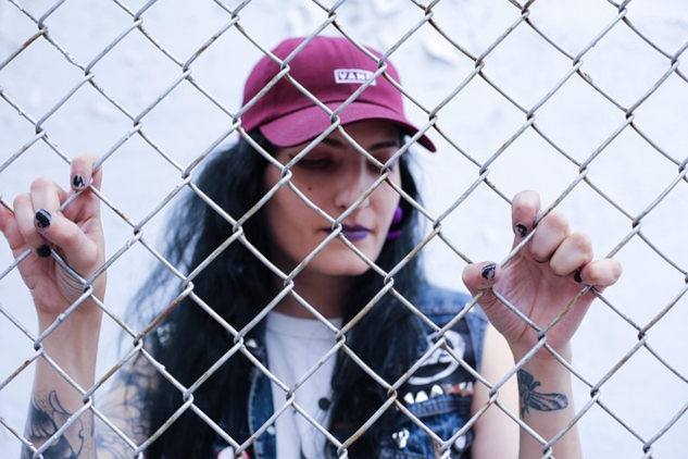 5 Ways to Break Free and Thrive A woman standing behind a chain link fence. Image by Daryl Bambic from Pixabay.
